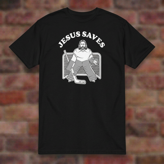 Jesus Saves Hockey T-shirt in Black, flat lay on blurred brick