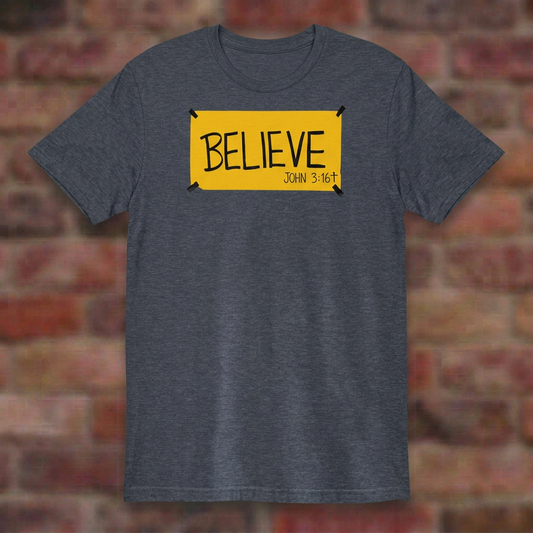 BELIEVE John 3:16 Heather Navy T-shirt flat lay on softly blurred bricks