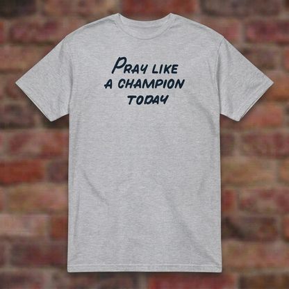 Pray Like a Champion T-shirt in Sport Grey, flat lay on blurred brick