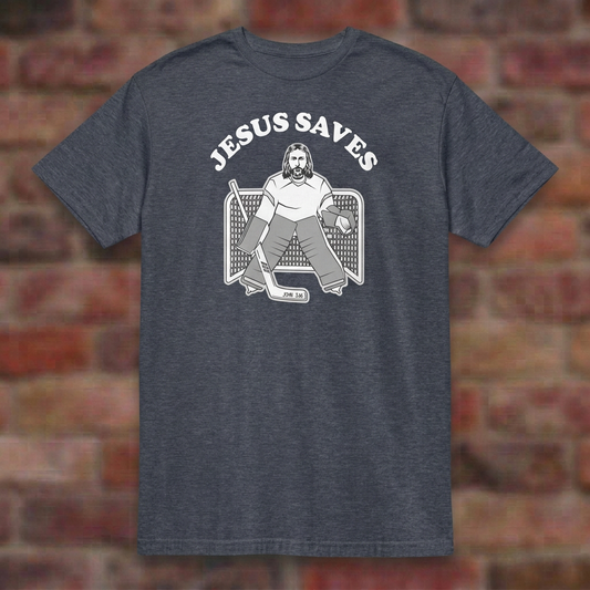 Jesus Saves Hockey T-shirt in Heather Navy, flat lay on blurred brick