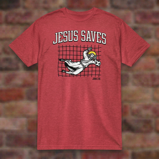 Jesus Saves Soccer T-shirt in Heather Red, flat lay on blurred brick
