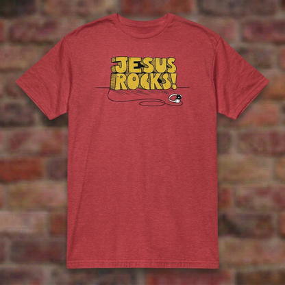 Jesus Rocks T-shirt in Heather Red, flat lay on blurred brick